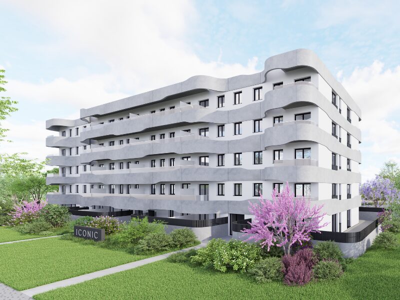 Fachada principal del edificio ICONIC Salou desde la calle, mostrando su diseño contemporáneo, líneas onduladas y acceso peatonal ajardinado.